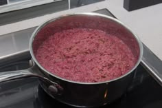 a pot filled with food sitting on top of a burner next to a window