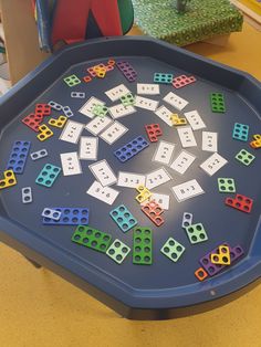 a blue tray filled with lots of different colored dominos on top of a table