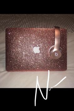 an apple headphone sitting on top of a laptop computer case that is covered in glitter