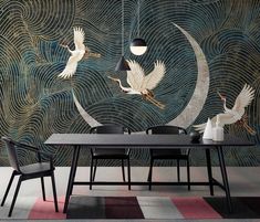 two birds flying over a table in front of a wall mural