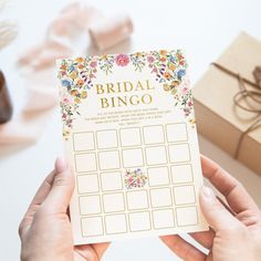 the bridal bingo game is being held up by someone's hands next to some gifts