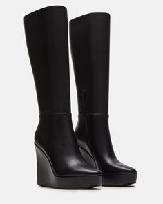 The AKIRA knee-high boot features a platform wedge design and a convenient inside zipper for easy on and off. Elevate your style game with this versatile and stylish boot, perfect for any occasion. 4.5 inch heel height Size 6 measurements: 14 inch shaft circumference, 13.75 inch shaft height Size 8 measurements: 15 inch shaft circumference, 14.75 inch shaft height Size 10 measurements: 16 inch shaft circumference, 15.75 inch shaft height Leather upper material Textile lining Synthetic sock Synth Winter Wedges, Knee High Wedge Boots, Black Wedge Boots, Knee High Platform Boots, Platform Boots Women, Summer Wardrobe Staples, Shoes Sandals Heels, Black Wedge, Stylish Boots