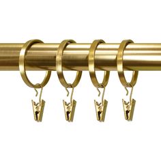 four brass rings hang from the end of a curtain rod with hooks on each side