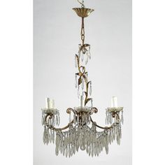 a chandelier hanging from the ceiling with crystal drops and leaves on it's arms