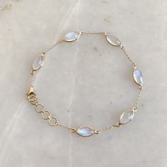 "ITEM DESCRIPTION: >> The bracelet is made from Solid 14K Yellow Gold. Gemstone used is absolutely natural and ethically sourced.  >> Natural Rainbow Moonstones cabochons and marquise shape with bezel setting is studded on it with utmost precision.  >> This is a minimalist design and is absolutely hassle-free and everyday jewelry.  ✓ Gem: Rainbow Moonstone ✓ Gem size & Shape: 5x10 mm (6 pcs) & marquis  ✓ Gem weight: 7.98 carats ✓ Bracelet Length: 7\" Inches + 0.5\" Inch Adjustable ✓ Gold purity: 14K (58.33% approx.) ✓ Gold weight: 1.57 grams  ✓ Gross weight: 3.17 grams The Gold purity is guaranteed and it comes with authentic 14K gold hallmark. Since these Bracelets are handmade, they are Nickel/Lead FREE.  CUSTOMISATION: --> The same design can be made in varying lengths of your choice. - Gold Moonstone Round Bracelets, Gold Moonstone Gemstone Bracelets, Gold Moonstone Bracelet With Gemstones, Elegant Moonstone Gemstone Bracelets, Elegant Moonstone Gemstone Bracelet, Dainty Round Moonstone Bracelets, Gold Moonstone Bracelet, Elegant Round Moonstone Crystal Bracelet, Gold Chain Bracelet