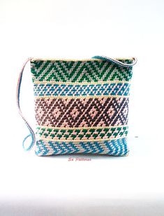 a small purse is shown on a white surface with blue, green and brown stripes