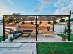 an outdoor living area with couches, tables and potted plants