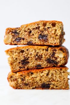 three pieces of fruit and nut bread stacked on top of each other in front of a white background