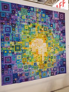 a large colorful quilt hanging on the wall