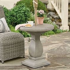 an outdoor table with a potted plant on it and a chair in the background