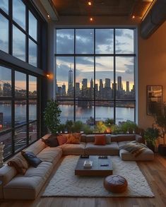 a living room filled with lots of furniture and large windows overlooking a cityscape