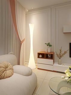 a living room with white furniture and flowers in vases on the table next to it