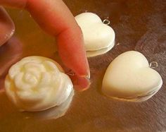 a hand touching some white stuff on top of a table next to other small items