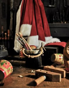 an assortment of wooden toys sitting on top of a table next to santa's hat