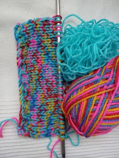 two skeins of yarn are next to each other on a knitting hook with a crochet hook in the foreground