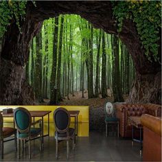 a living room filled with lots of furniture next to a forest covered in green trees