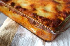 a casserole dish with meat and cheese in it sitting on a white towel