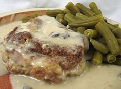 a close up of a plate of food with green beans and gravy on it