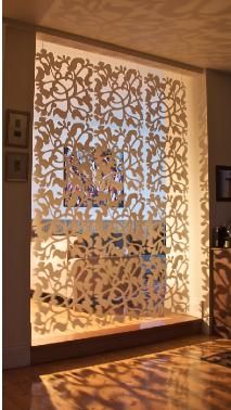 an intricate laser cut screen in the corner of a room with sunlight streaming through it