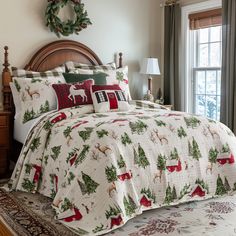 a christmas themed bed spread with deer and pine trees on it, in front of a window