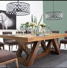 a dining room table with chairs and pictures on the wall in the backround