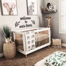 a baby's room with grey walls and pictures on the wall