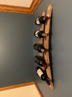 a wooden wine rack filled with bottles on top of a wall