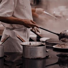 a chef is cooking in a kitchen with pots and pans