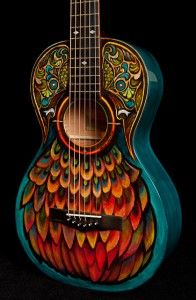 a colorful guitar with an intricate design on it's back and sides, against a black background