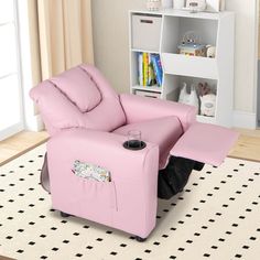 a pink recliner chair sitting on top of a white rug in front of a book shelf