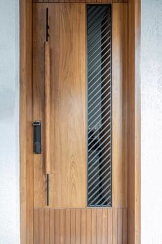 a wooden door with an iron screen on the side and glass paneling around it