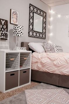 a bedroom with white walls, pink bedding and lots of decorations on the wall