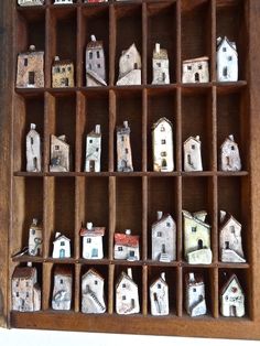 a wooden shelf filled with miniature houses on top of it