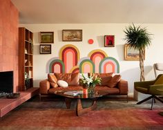 a living room filled with furniture and a painting on the wall above it's fireplace