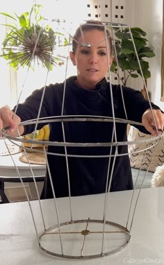 a woman is making a sculpture out of wire