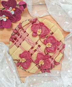 a pie with flowers on it sitting on top of a wooden table