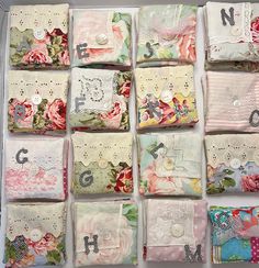 many different pieces of fabric with flowers and letters on them are arranged in a box