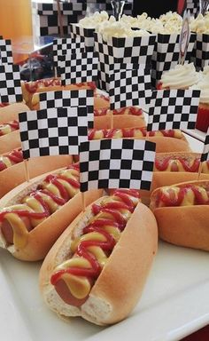 hotdogs with ketchup and mustard are on display at a race themed birthday party