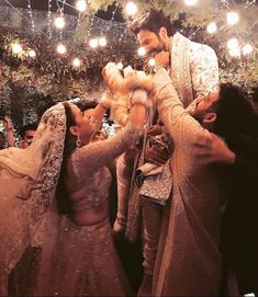 the bride and groom are getting ready for their wedding ceremony at night with string lights in the background