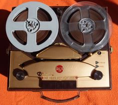 an old fashioned movie projector with two reels on it's side and one in the middle