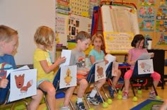 there are many children sitting in the classroom with their pictures on them and one is holding a book