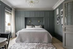 a bedroom with gray walls and white bedding