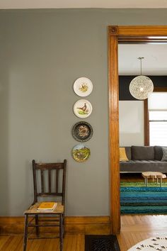 the interior of a living room with gray walls and wood flooring is shown in color swatches