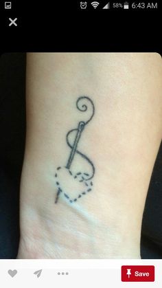 a black and white photo of a small tattoo on the wrist, with a musical note coming out of it