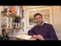 a man sitting at a desk with a book in front of him