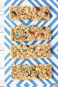 three granola bars on a blue and white striped napkin with m & ms in the middle