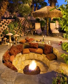 an outdoor fire pit surrounded by plants and trees