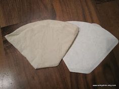 three pieces of white cloth sitting on top of a wooden floor next to each other