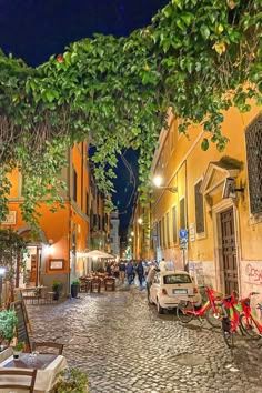 a cobblestone street at night with parked bicycles