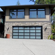 a house with a garage and stairs leading up to the front door that has windows on each side